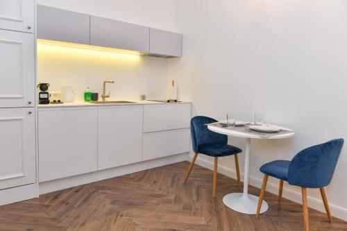 a kitchen with two blue chairs and a table at Luxury Studio next to Monte Carlo in Beausoleil