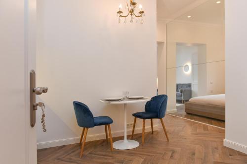 a dining room with a table and two blue chairs at Luxury Studio next to Monte Carlo in Beausoleil