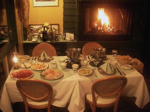 a table with plates of food and a fireplace at Auberge Mountain View Inn in Mont-Tremblant