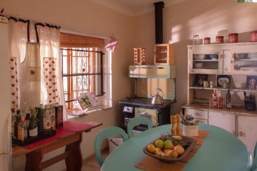 a kitchen with a table with a bowl of fruit on it at The Cherry Stone Country House in Fouriesburg