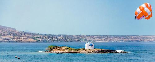 a small island with a lighthouse in the water at Pyrgos Blue in Malia