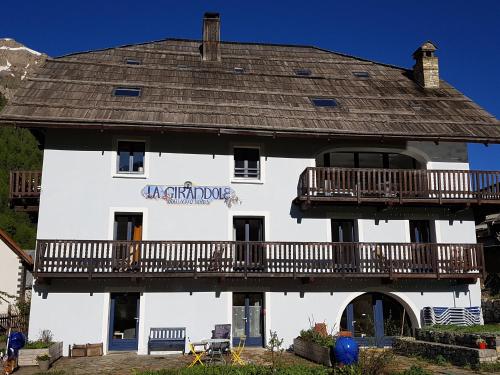 a large white building with a balcony on it at La Girandole Chambre d'hôtes et Location d'appartement in Arvieux
