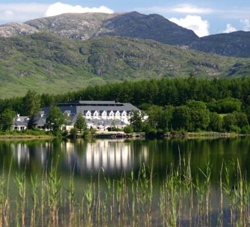a large house sitting on the shore of a lake at Leghowney House in Donegal