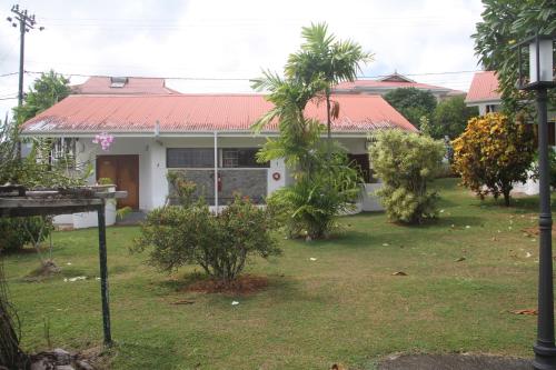 a house with trees in front of it at Daniella's Bungalows in Bel Ombre