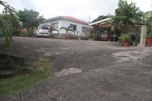 an empty driveway with a van parked in front of a house at Daniella's Bungalows in Bel Ombre