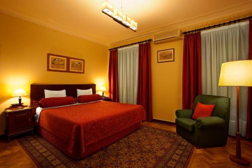 a hotel room with a bed and a chair at Pao de Acucar Hotel in Porto