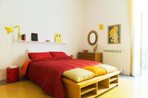 ナポリにあるViky's Home B&Bのベッドルーム1室(赤と黄色の毛布を使用したベッド1台付)