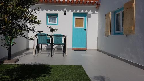 two chairs and a table in front of a door at Casa Aurea in Odeceixe