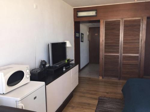 um quarto com um micro-ondas e uma televisão num balcão em Casa Tarik em Portimão