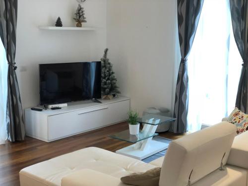 a living room with a tv and a white couch at Berga Exclusive Suite in Bari