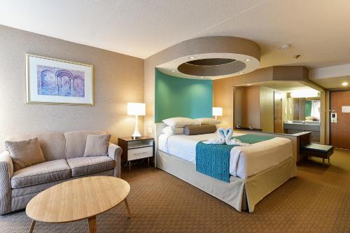 a large hotel room with a bed and a couch at Howard Johnson Plaza by Wyndham by the Falls Niagara Falls in Niagara Falls