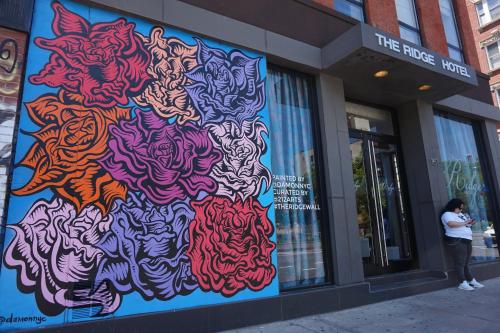 a woman standing outside of a store with a painting on the wall at The Ridge in New York