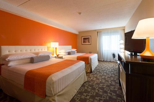 a hotel room with two beds and a flat screen tv at Howard Johnson Plaza by Wyndham by the Falls Niagara Falls in Niagara Falls