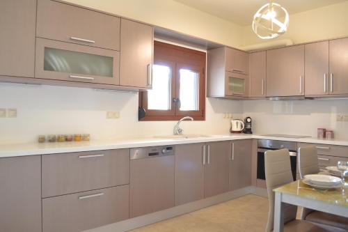 a kitchen with brown cabinets and a table with a tableablish at Ariadni's Maisonette in Yiofirákia