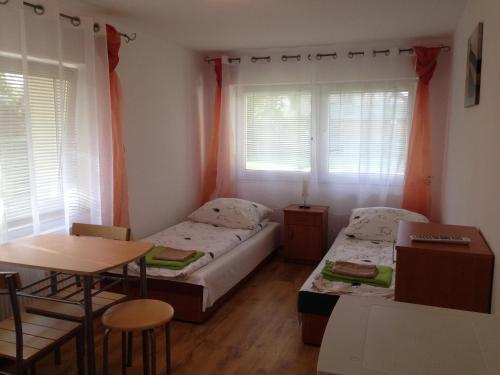 Habitación pequeña con 2 camas y mesa. en Pokoje goscinne Jaskolcze Gniazdo, en Dziwnówek