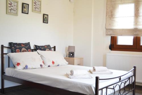 een slaapkamer met een bed met witte lakens en kussens bij Ariadni's Maisonette in Yiofirákia