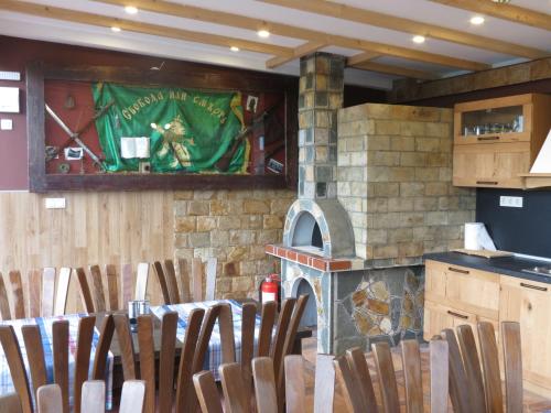 a group of chairs in a kitchen with a fireplace at Aurora Guest House in Golden Sands
