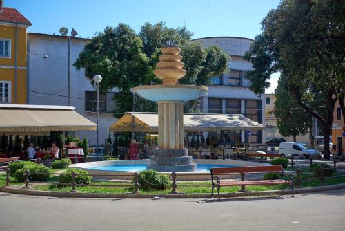 a fountain in the middle of a park with two benches at Old City Romanitic Studios 1 with FREE private parking in Pula