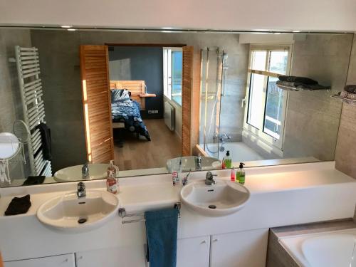 łazienka z 2 umywalkami i dużym lustrem w obiekcie Front de mer - Victoria - Appartement 120m2 w mieście Carnac