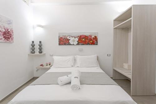 a white bedroom with a bed with towels on it at La Loggia dei Raynò in Lecce