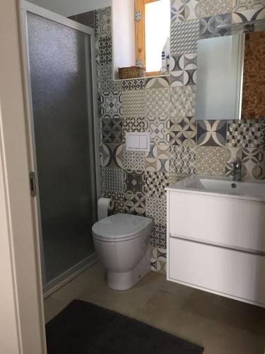 a bathroom with a toilet and a sink at Casa le Gebbie in Marzamemi