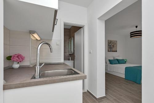 a kitchen with a sink and a bedroom with a bed at Apartment Kate in Podgora