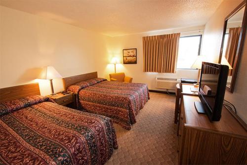 a hotel room with two beds and a television at Superior Inn in Superior