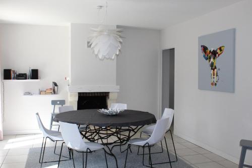 une salle à manger avec une table noire et des chaises blanches dans l'établissement Clos du Pere Ignace, à Saint-Martin-de-Ré