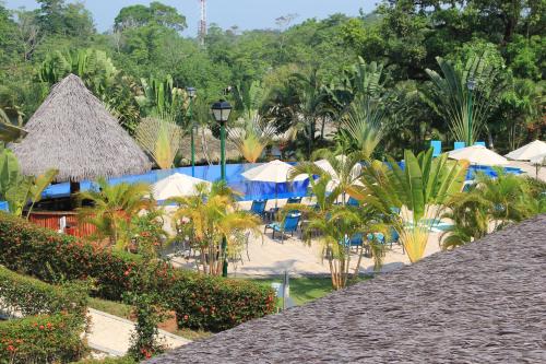 a view of a resort with a pool and umbrellas at Hotel Villa Mercedes Palenque in Palenque