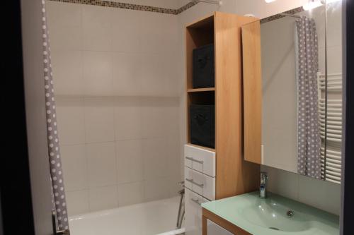 a bathroom with a tub and a sink and a mirror at Clos du Pere Ignace in Saint-Martin-de-Ré