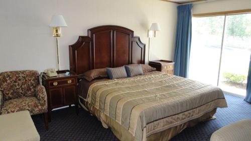 a hotel room with a large bed and a chair at Harbor Base Inn in Newport