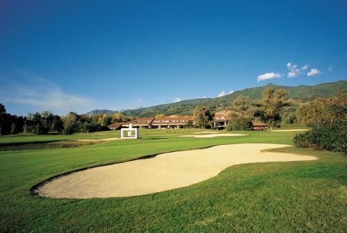 
a large green field with a blue sky at Versilia Golf Resort in Forte dei Marmi
