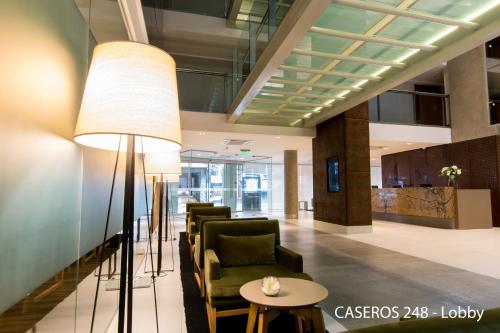 a lobby with chairs and a table and a lamp at Caseros 248 Hotel in Cordoba