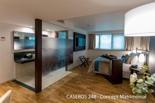a hotel room with a bed and a glass wall at Caseros 248 Hotel in Cordoba