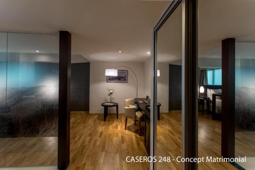 a living room with a table and a chair and a mirror at Caseros 248 Hotel in Cordoba