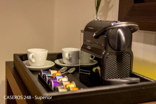 a kitchen counter with a coffee maker and two cups at Caseros 248 Hotel in Cordoba