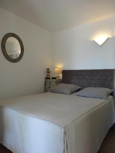 une chambre avec un grand lit blanc et un miroir dans l'établissement La Croix Valmer, à La Croix-Valmer