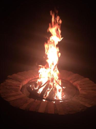 a fire in a brick fire pit at night at Lemon home in Dziemiany