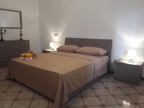 a bedroom with a bed with two lamps and a mirror at I Fiori Di Lucrezia in Monteroni di Lecce