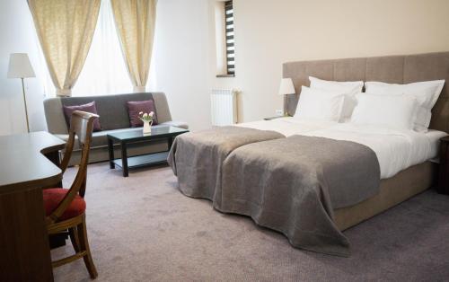 a hotel room with a large bed and a chair at Nest in Drobeta-Turnu Severin