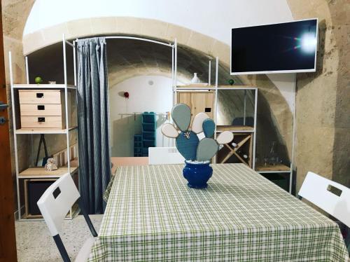 casa vacanza Regina في غروتاليي: غرفة مع طاولة عليها مزهرية زرقاء