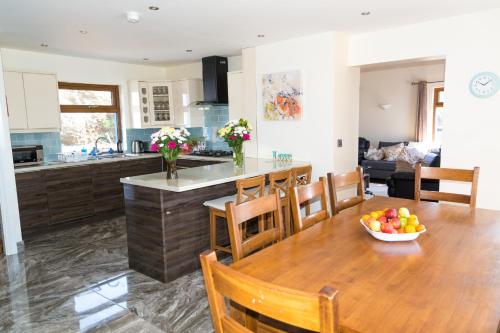 a kitchen and dining room with a table with a bowl of fruit at Atlantic rest in Dingle