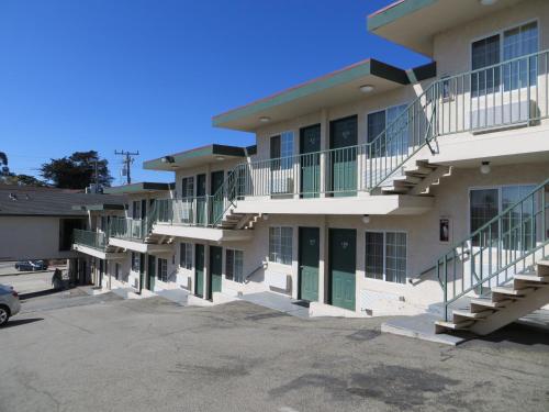 a row of apartment buildings with green doors and stairs at Beachview Inn in Santa Cruz