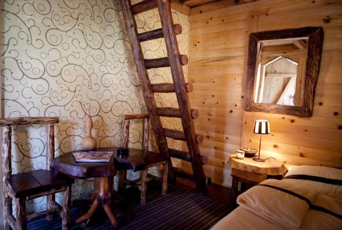 a bedroom with a bed and a ladder and a table and a mirror at Royal Village Kotromanićevo in Vranduk