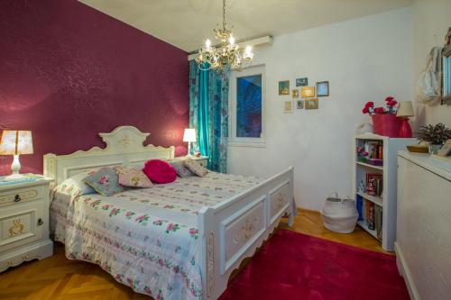 a bedroom with a white bed and a purple wall at Apartment Valerija in Jesenice