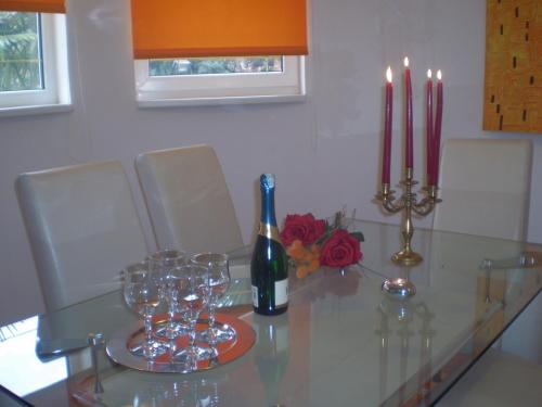 a glass table with a bottle of wine and wine glasses at Villa Jelena in Zadar