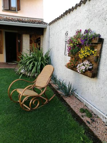 a chair sitting on the grass in a garden at Alberta in Bertiolo