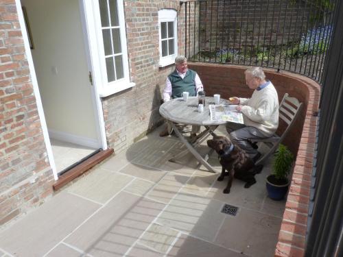 two men and a dog sitting at a table at The Old Mill Bed and Breakfast in Bere Regis