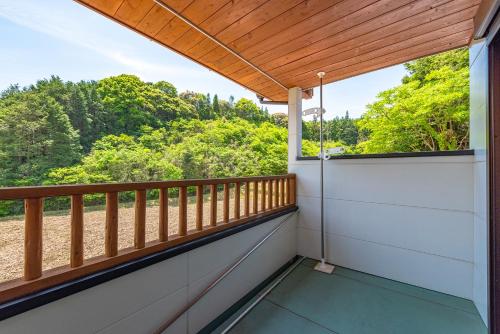 a balcony with a view of the woods at Share Creative&Bed adonoan in Takeo