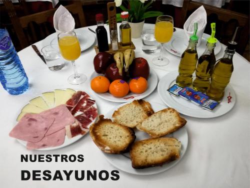 een witte tafel met borden eten en drinken bij LA COCHERA in Madrigal de la Vera